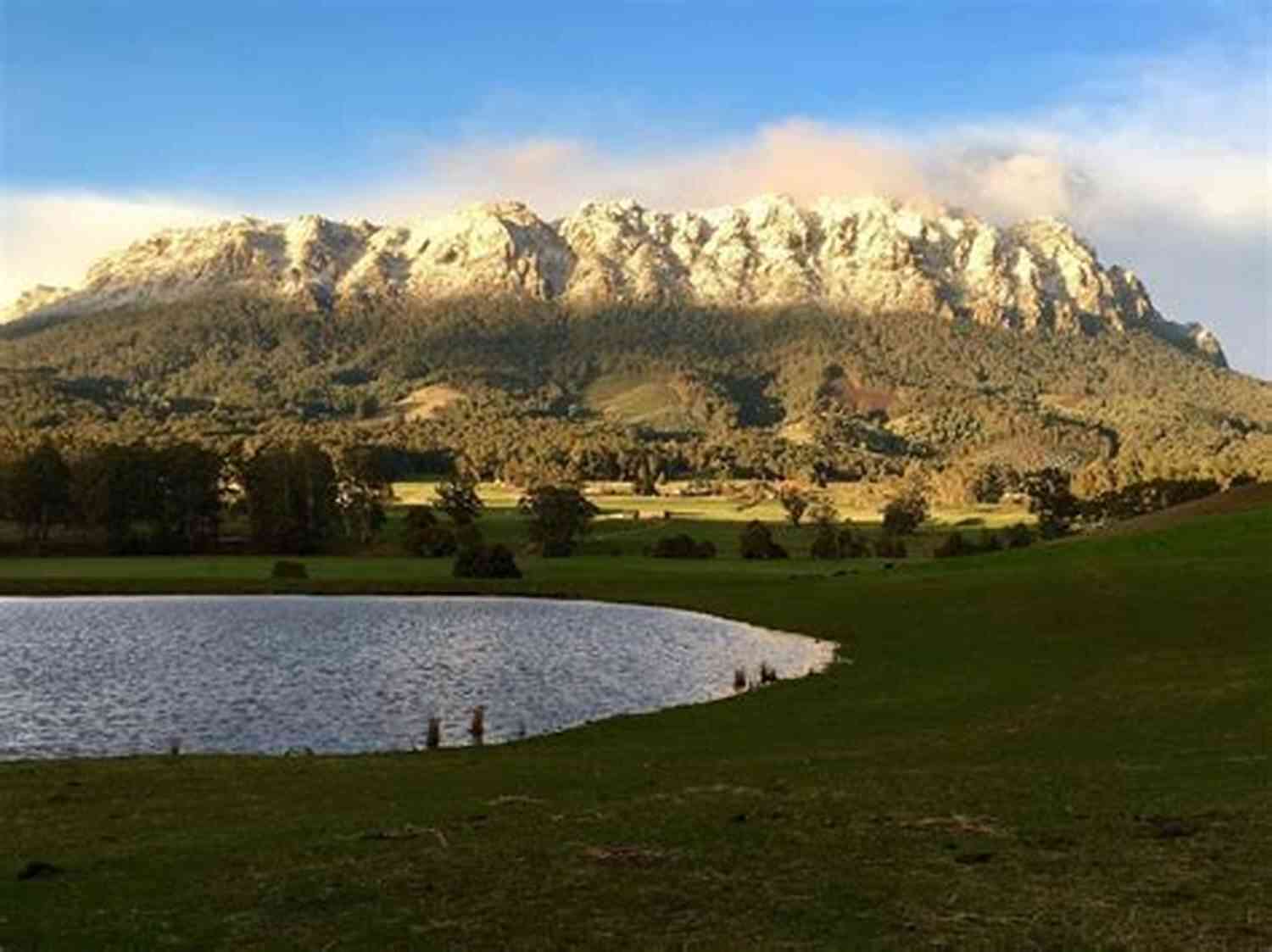 A Majestic View Of Mount Roland Britt Surrounded By Lush Greenery And A Clear Blue Sky. The Compulsory Mount Roland Britt